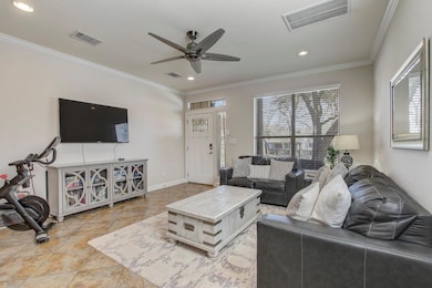 Living room featuring visible vents, a ceiling fa