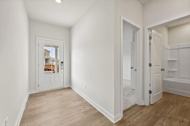 Foyer featuring light wood-style flooring and baseboards