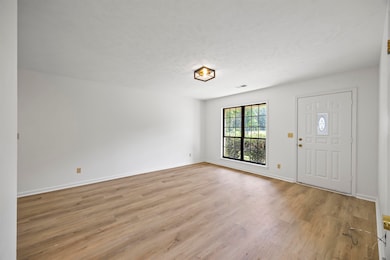 Entryway with light wood finished floors and a textured ceiling