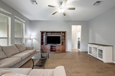 Living room featuring a ceiling fan and wood fini