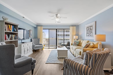 Living room featuring ceiling fan, ornamental mold