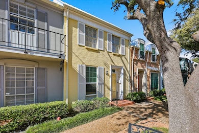 View of front of home with brick siding and a balcony