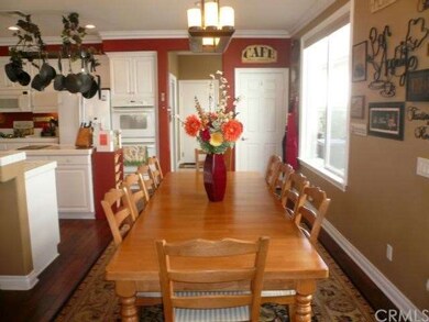 Large dinette with wood floor and custom light fix