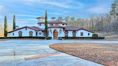 Mediterranean / spanish-style home featuring a tiled roof, stucco siding, and curved driveway