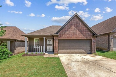 View of front of home with brick siding, concrete driveway, a garage, and a front lawn