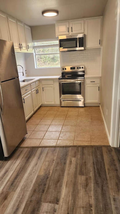 Kitchen featuring tasteful backsplash, stove, ref