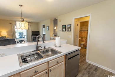 Kitchen with light brown cabinetry, stainless stee