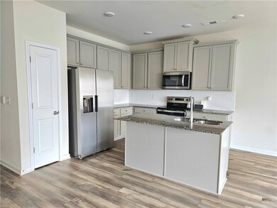 Kitchen with a sink, stone counters, appliances wi