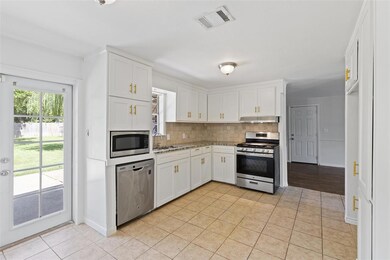 Updated kitchen features white cabinets, stainless