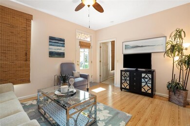 Living room with wood flooring, ceiling fan with l