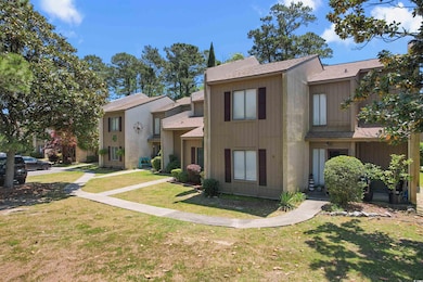 Multi unit property with a shingled roof and a front yard