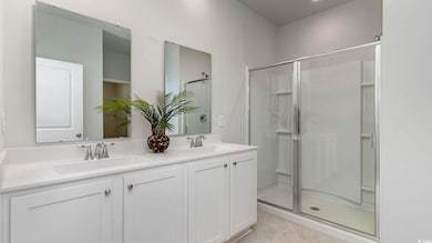 Bathroom with tile patterned flooring, vanity, and a shower with shower door