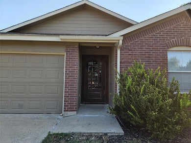 Entrance to property with brick siding and a garage