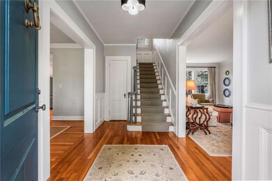 Foyer featuring stairway, crown molding, and wood 