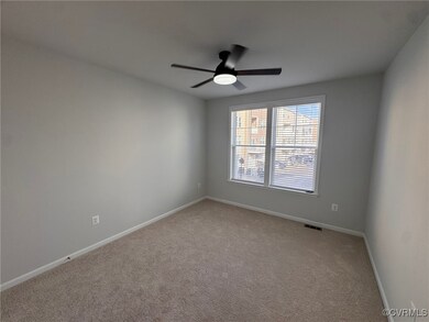 Spare room featuring ceiling fan and light carpet