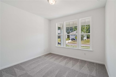 Carpeted empty room featuring baseboards