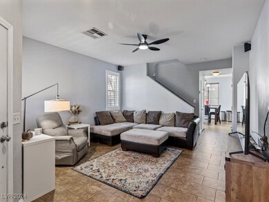 Living room with tile floors, shutters, ceiling fa