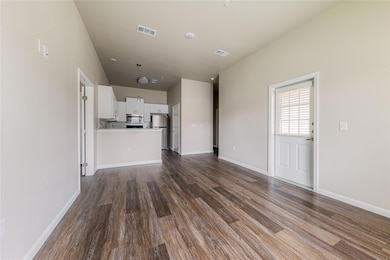 Unfurnished living room with dark wood-style floo
