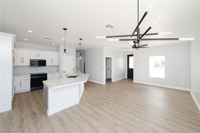 Kitchen with stove, black microwave, light wood-st