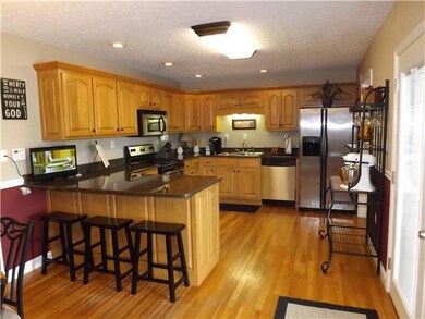 Kitchen with stainless appliances, granite countertops & peninsula bar