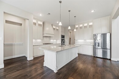 Your chef inspired kitchen awaits! Features include quartz countertops paired with a coordinating stone backsplash, Stainless Steel appliances, crisp white cabinets, under cabinet lighting, recessed lighting, and a sprawling island with breakfast bar seating.