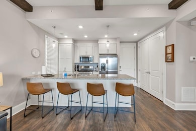 Kitchen with visible vents, a peninsula, a breakfa