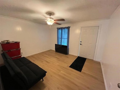 Entryway featuring light wood-style flooring, ornamental molding, and ceiling fan