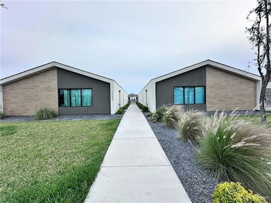 View of front of home with stucco siding, brick siding, and a front yard