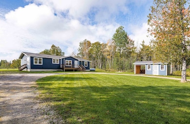 View of front facade with an outdoor structure and a front yard, and storage building.