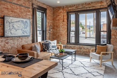 Living area featuring concrete flooring and brick