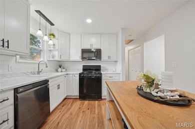 Kitchen featuring white hardward adorned cabinets, simply stated backsplash, pendant lighting, butcher block countertops, and recessed lighting