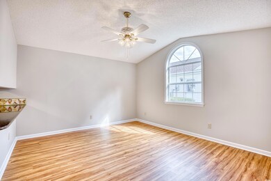 Spare room with vaulted ceiling, a ceiling fan, a 
