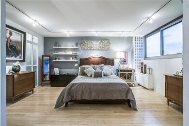 Spacious master bedroom with elegant wood floors a
