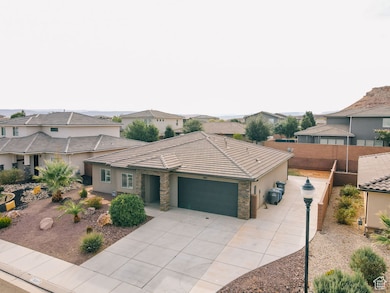 View of front of house with a residential view, an attached garage, concrete driveway, stucco siding, and stone siding