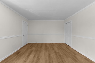 Spare room featuring baseboards, wood finished fl
