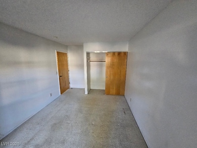 Unfurnished bedroom with a closet and a textured c