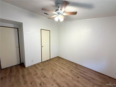 Unfurnished bedroom with light wood finished floors, a textured ceiling, and ceiling fan