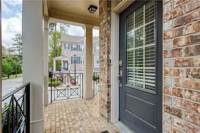 Doorway to property with covered porch and brick siding