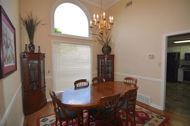 Formal dining room has arched window and vaulted c