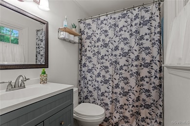 Bathroom with vanity, toilet, and a shower with cu