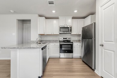 The kitchen is upgraded with Whirlpool appliances and granite countertops.