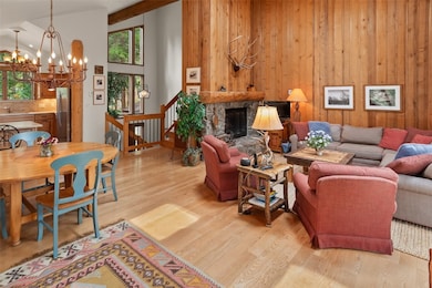 Living area with a chandelier, wooden walls, light