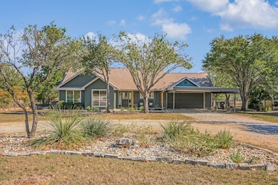 View of front of house with dirt driveway, a porch, and an attached garage