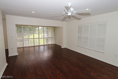Unfurnished room with dark wood-type flooring and ceiling fan