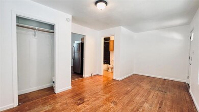 Unfurnished bedroom featuring freestanding refrig