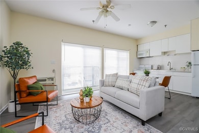 Living room with ceiling fan, sink, and light hard