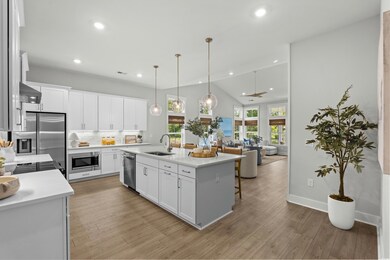 Kitchen featuring open floor plan, decorative light fixtures, white cabinetry, recessed lighting, and light wood-style flooring
