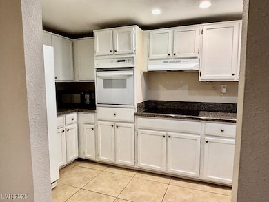 Kitchen with black appliances, under cabinet range