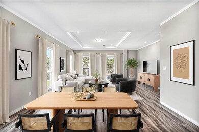 Dining space with ornamental molding, a raised ceiling, and wood finished floors