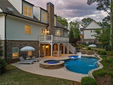 Back of house at dusk featuring a patio, a pool wi